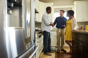 ServiceMaster Restore technician and homeowner shaking hands in kitchen