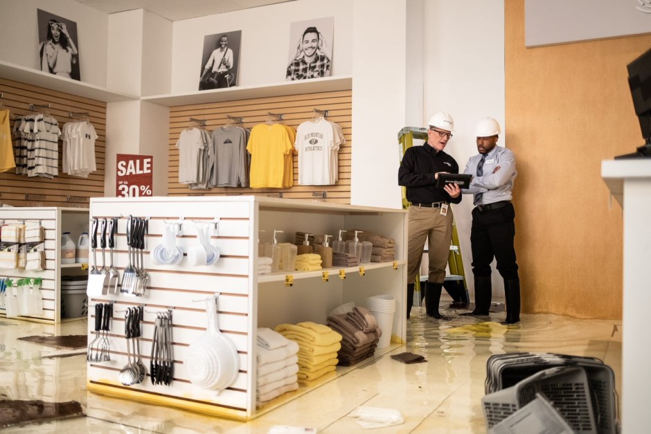 A ServiceMaster Restore technician discusses restoration plans with a retail store manager in a flood-damaged store